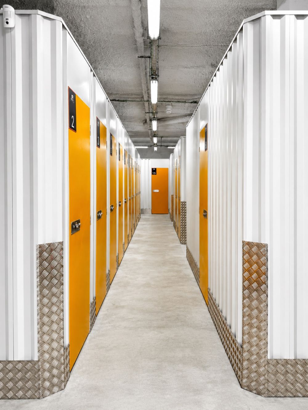 Pasillo interior de un centro TrasterosGO con puertas naranjas